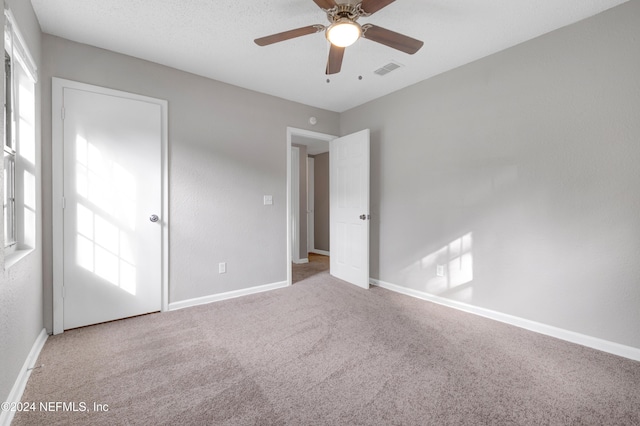 unfurnished room with carpet, ceiling fan, and a healthy amount of sunlight