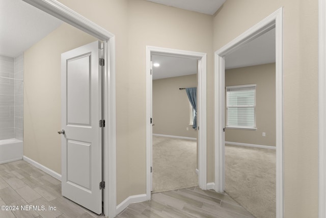 hallway with light colored carpet