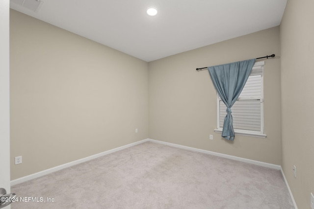 unfurnished room featuring light carpet