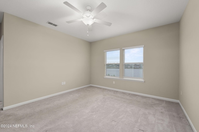 carpeted spare room featuring ceiling fan