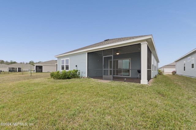 back of house featuring a sunroom and a yard