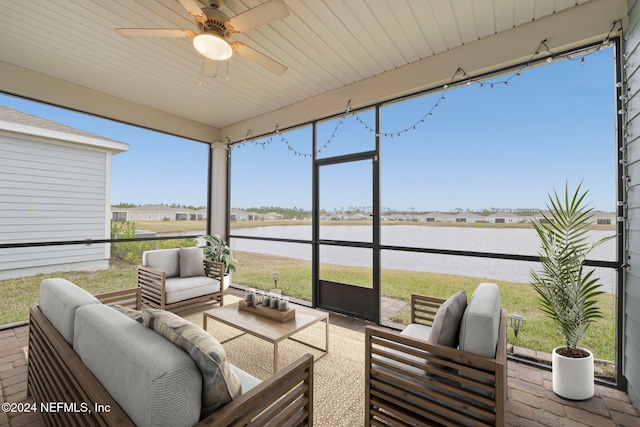 sunroom / solarium featuring ceiling fan, plenty of natural light, and a water view