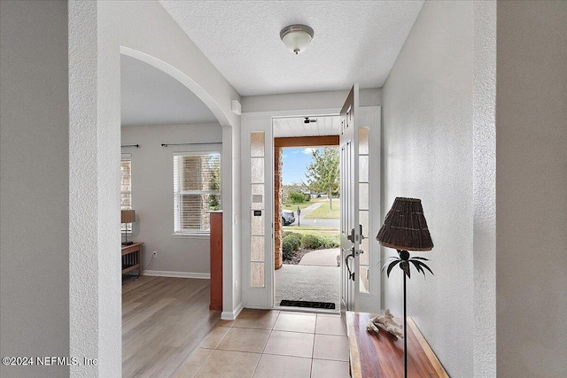 foyer featuring light hardwood / wood-style flooring and a textured ceiling