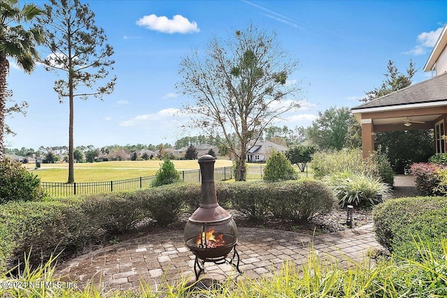 view of yard with ceiling fan, a patio area, and an outdoor fire pit