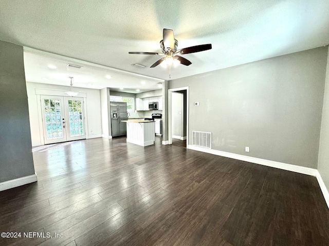 unfurnished living room featuring a textured ceiling, ceiling fan, dark hardwood / wood-style flooring, and french doors