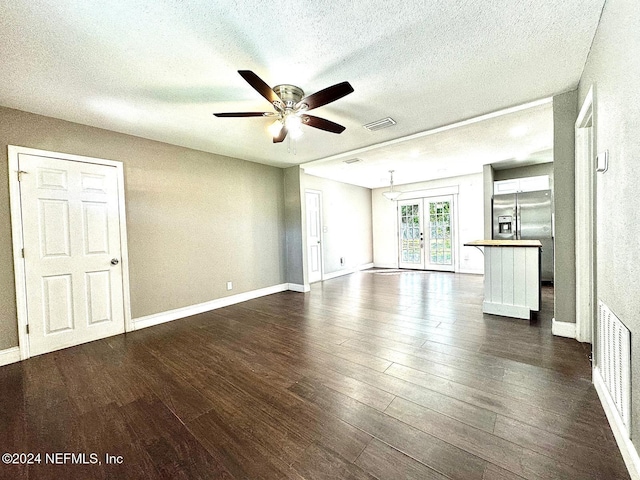 unfurnished living room with french doors, a textured ceiling, dark hardwood / wood-style floors, and ceiling fan