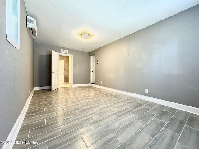 empty room with wood-type flooring and a wall mounted AC