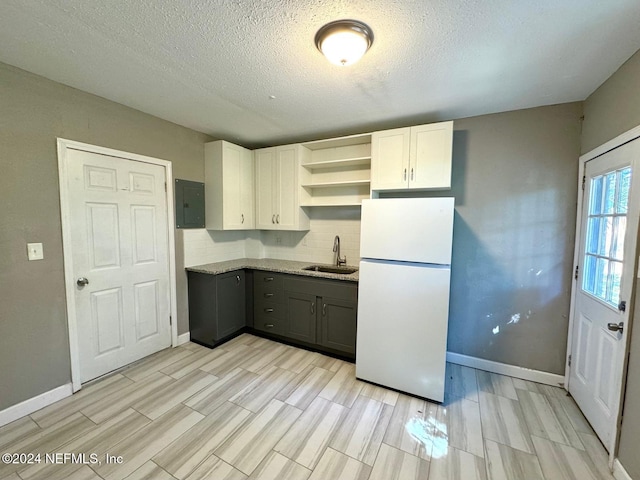 kitchen with light wood-type flooring, gray cabinetry, sink, white cabinets, and white fridge