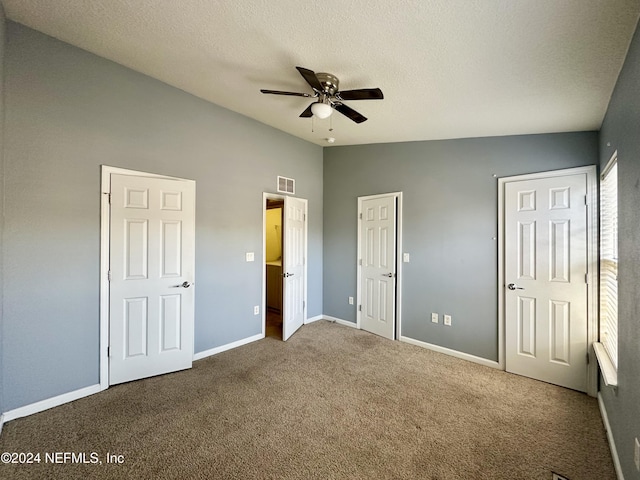 unfurnished bedroom with a textured ceiling, ceiling fan, carpet floors, and lofted ceiling