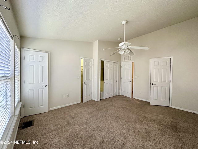 unfurnished bedroom featuring carpet flooring, a textured ceiling, ceiling fan, and lofted ceiling