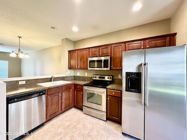 kitchen with sink, an inviting chandelier, decorative light fixtures, light tile patterned floors, and appliances with stainless steel finishes