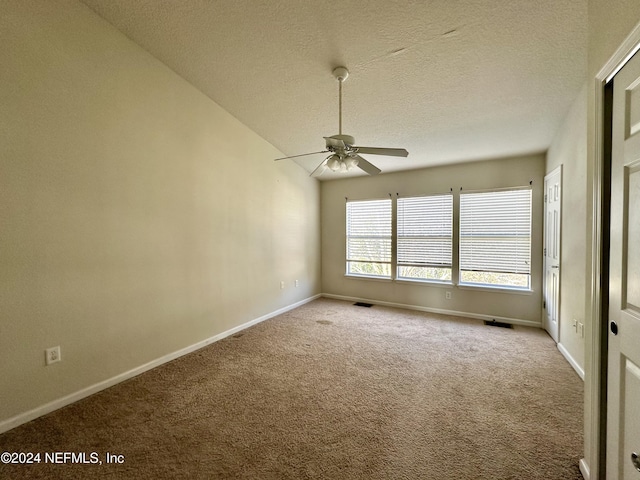 spare room with carpet flooring, ceiling fan, lofted ceiling, and a textured ceiling