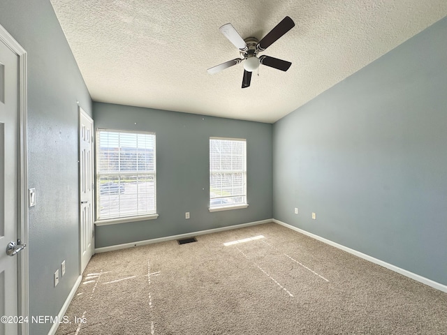 spare room featuring light carpet and a textured ceiling