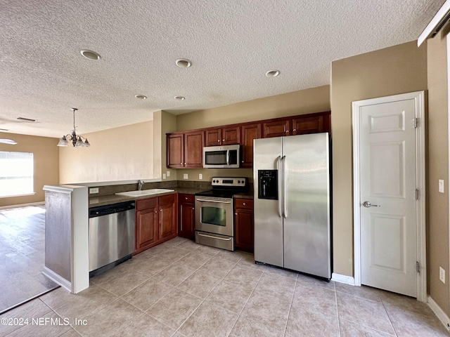 kitchen with sink, stainless steel appliances, an inviting chandelier, kitchen peninsula, and pendant lighting