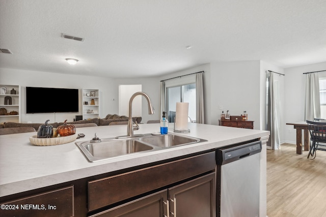 kitchen featuring dark brown cabinets, a textured ceiling, stainless steel dishwasher, and sink