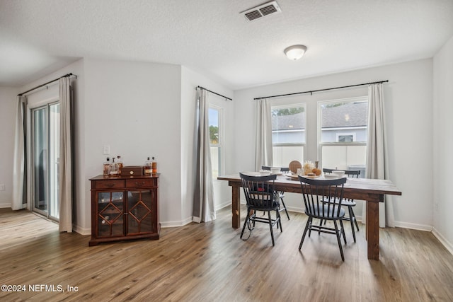 dining room featuring hardwood / wood-style floors and a textured ceiling