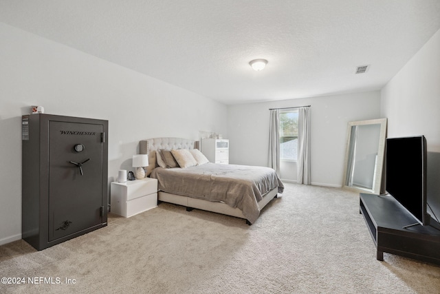 bedroom featuring a textured ceiling and light colored carpet