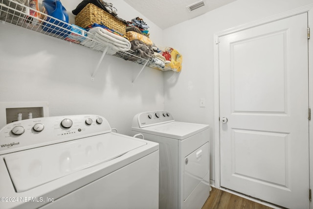 clothes washing area with dark wood-type flooring and independent washer and dryer