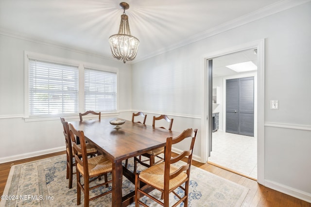 dining area featuring hardwood / wood-style flooring, a notable chandelier, and crown molding