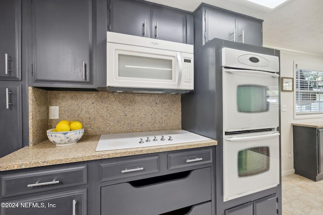 kitchen featuring decorative backsplash, light tile patterned floors, white appliances, and ornamental molding