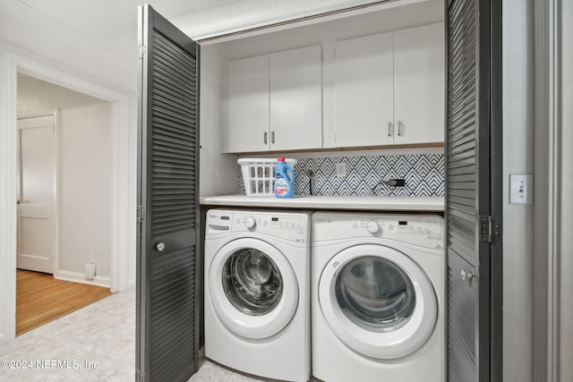 laundry area with cabinets, light tile patterned flooring, and washer and dryer