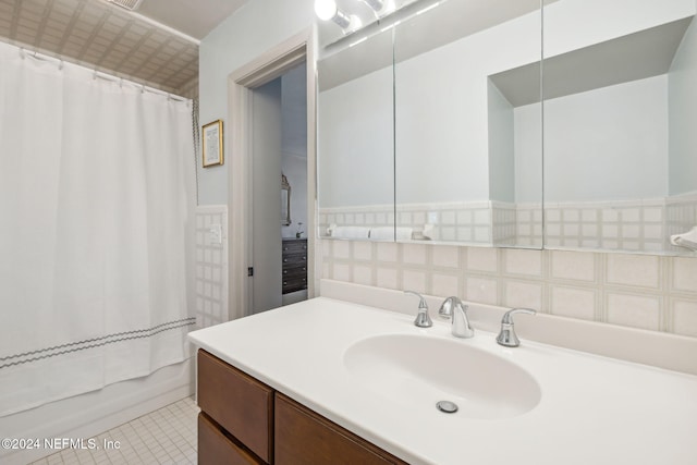 bathroom featuring tile walls, tile patterned flooring, vanity, and shower / bath combo