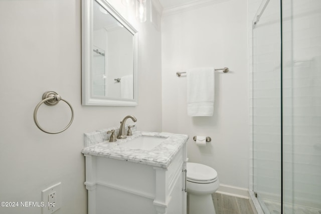 bathroom featuring crown molding, toilet, vanity, a shower with shower door, and hardwood / wood-style flooring