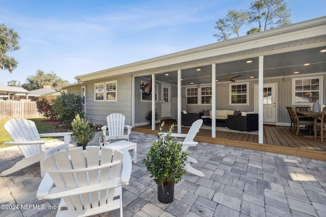 view of patio with an outdoor living space, ceiling fan, and a wooden deck