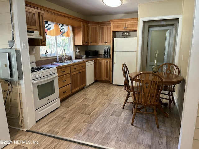 kitchen with white appliances, sink, and light hardwood / wood-style flooring