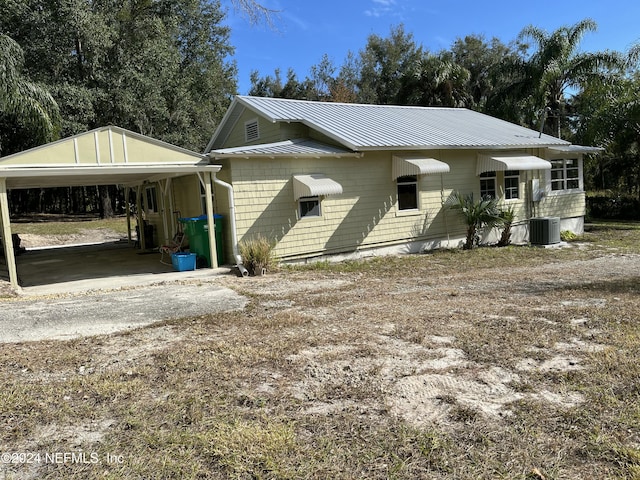 view of front facade with central AC unit and a carport