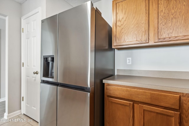 kitchen with stainless steel fridge and light tile patterned floors