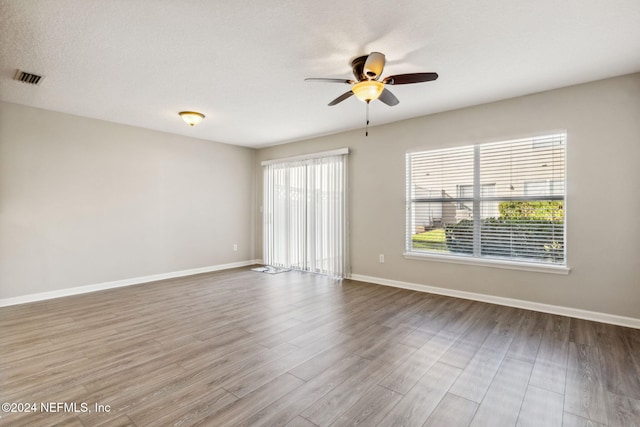 spare room with hardwood / wood-style flooring, ceiling fan, and a textured ceiling