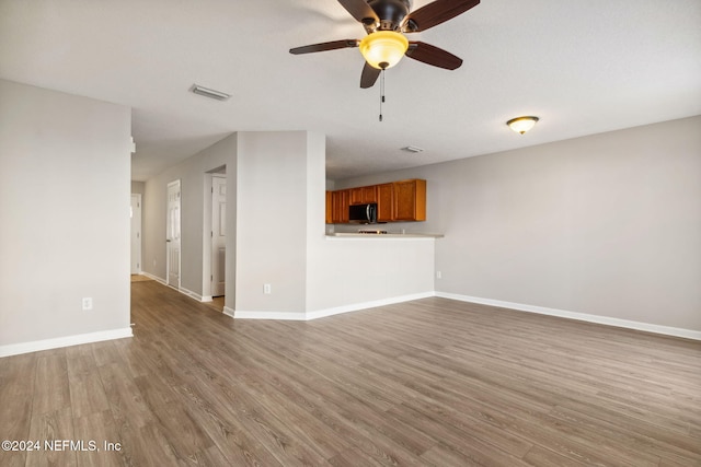 unfurnished living room with hardwood / wood-style floors and ceiling fan