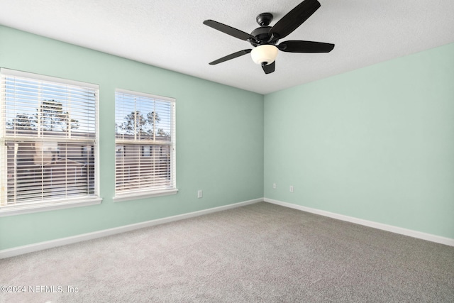 empty room with carpet flooring, a textured ceiling, and ceiling fan