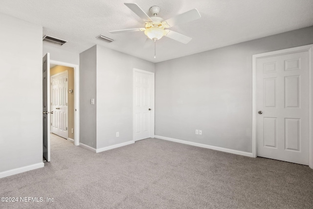 unfurnished bedroom featuring a textured ceiling, ceiling fan, and light carpet