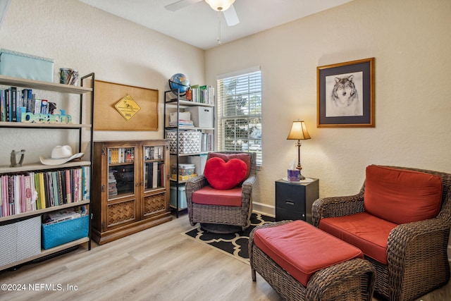 sitting room with ceiling fan and wood-type flooring