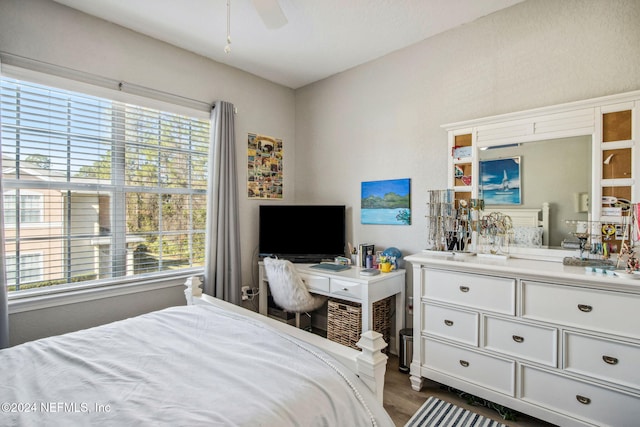 bedroom with multiple windows, ceiling fan, and dark wood-type flooring