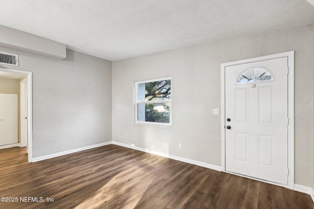 foyer with a textured ceiling and dark hardwood / wood-style floors