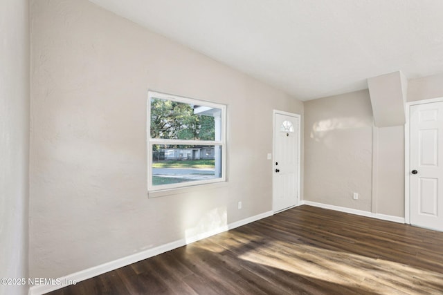 unfurnished room with dark wood-type flooring and vaulted ceiling