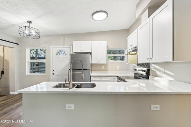 kitchen with stainless steel appliances, dark hardwood / wood-style floors, kitchen peninsula, pendant lighting, and white cabinets