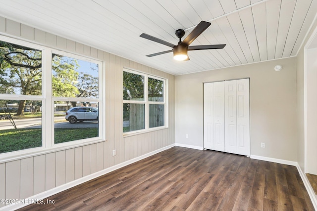 unfurnished bedroom featuring multiple windows, ceiling fan, a closet, and dark hardwood / wood-style floors