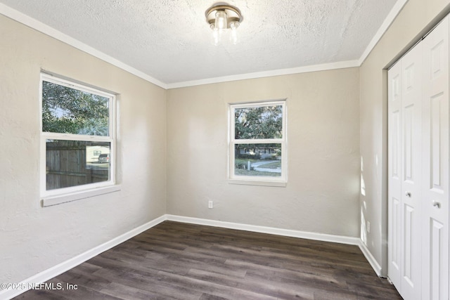 unfurnished bedroom with a textured ceiling, crown molding, a closet, and dark wood-type flooring