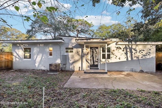 rear view of house with central air condition unit and a patio area