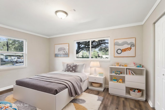 bedroom featuring multiple windows, dark wood-type flooring, and ornamental molding