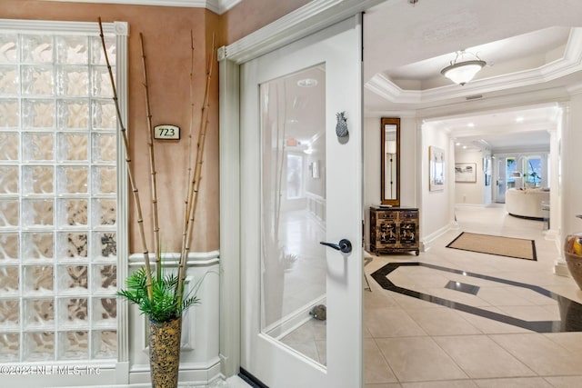 bathroom featuring french doors, tile patterned floors, a raised ceiling, and ornamental molding