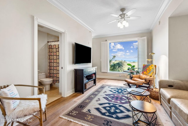 living room with crown molding, ceiling fan, a textured ceiling, and light wood-type flooring