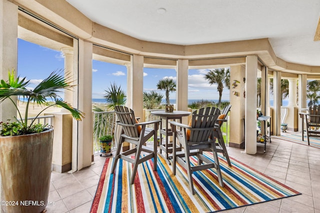 sunroom / solarium featuring a water view