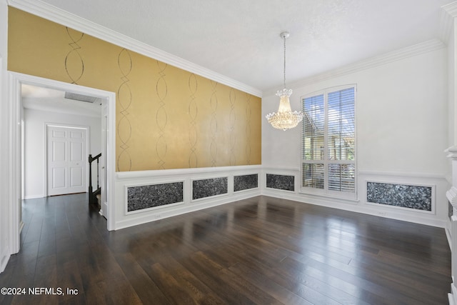 spare room with crown molding, dark hardwood / wood-style flooring, and a chandelier