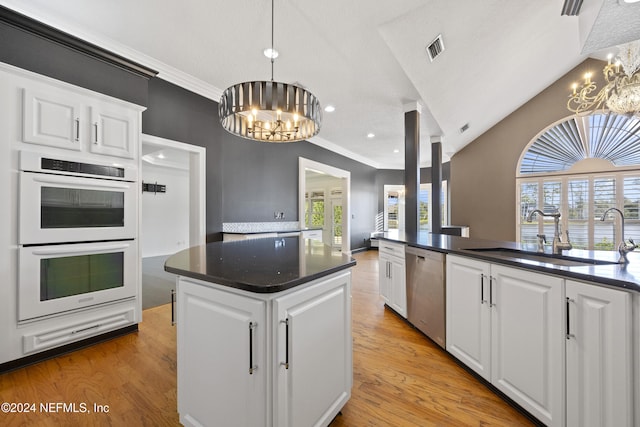 kitchen featuring white cabinets, dishwasher, double oven, and an inviting chandelier