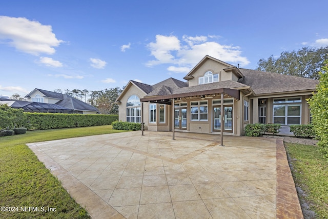 rear view of property featuring french doors, a yard, and a patio area